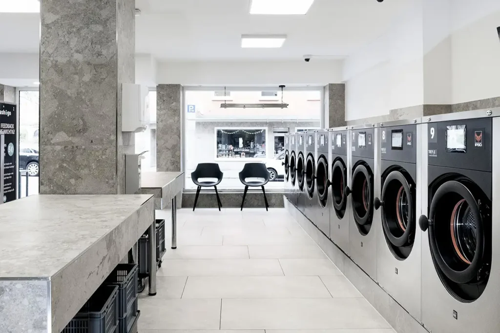 Lange Reihe moderner Industriewaschmaschinen im Wash&Go SB-Waschsalon Stuttgart West.